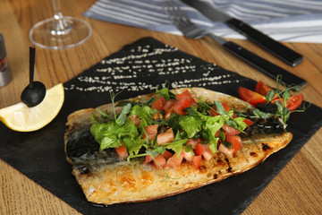 Delicious grilled fish served on wooden table