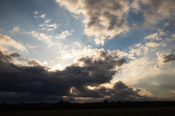 Cloudscape at sunset times with sun beams passing the clouds