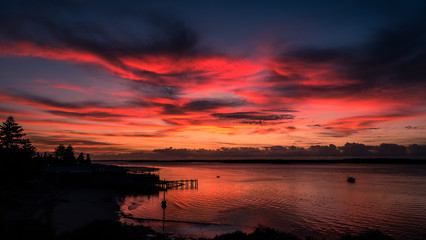 Colourful clouds at dawn over bay