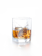 splash of whiskey with ice osolated on white