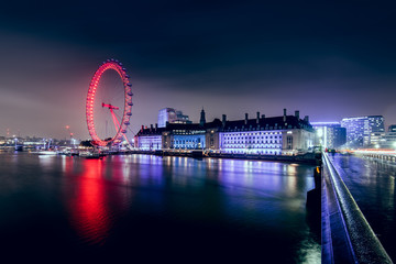 The London Eye Ferris Wheel Illuminated With Red Light at Night - obrazy, fototapety, plakaty