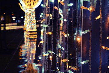 Naklejka na ściany i meble Christmas lights with reflection on the street, rainy day.