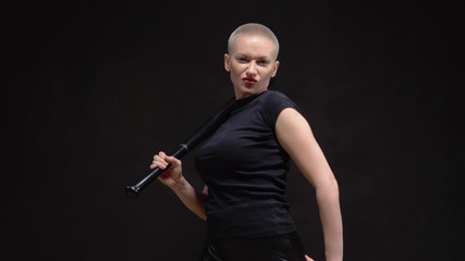 beautiful short haired blond woman  with a baseball bat on black background