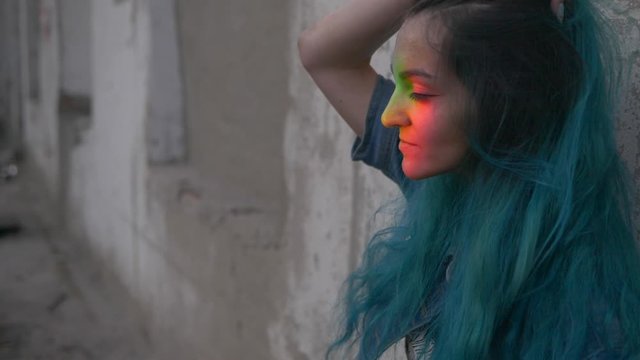 LGBT girl with a rainbow on her face beautifully smokes vape