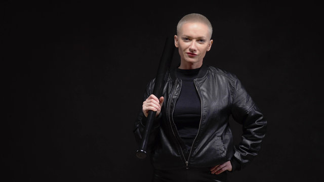  short haired blond woman in a black leather jacket with a baseball bat 