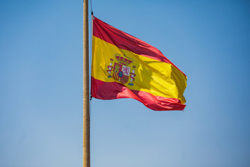 Waving flag of Spain hanging on the Kingdom of Spain institutions and administrative building in Alicante, Valencia, Spain