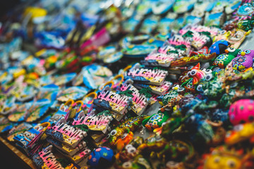 Obraz premium View of traditional tourist souvenirs and gifts from Spain, Alicante, Valencia with toys, bull figures, flamenco dancer dolls, fridge magnets with and key ring keychain, in local vendor souvenir shop