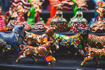 View of traditional tourist souvenirs and gifts from Spain, Alicante, Valencia with toys, bull...