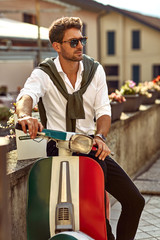 Stylish italian man wearing white shirt and sitting on classic scooter - 308846596