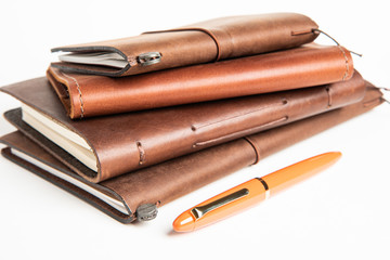 Leather-Bound Journals And An Orange Fountain Pen