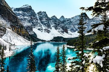 Moraine lake panorama in winter with frozen water and snow covered mountains, Banff National Park,...