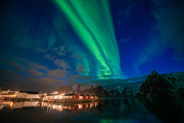 Aurora borealis on the Lofoten islands, Norway. Green northern lights above mountains. Night sky with polar lights. Night winter landscape