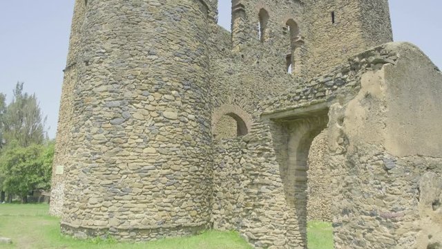 Camera forward tilt up to reveal external walls and facade of Fasilides Archive ruins in the Fasil Ghebbi royal enclosure in Gondar, Ethiopia