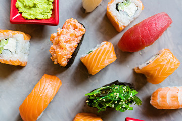 Top view on traditional japanese empty with sushi, ginger, soy sauce, wasabi on concrete gray background, mock up, flat lay. Online food delivery concept