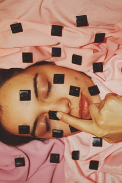 Overhead view of woman's finger pressing keyboard key on her face