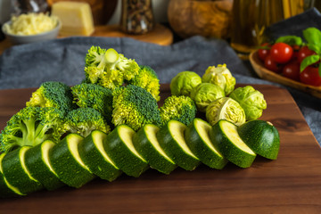 Broccoli, brussels sprouts and sliced courgette on a wooden board