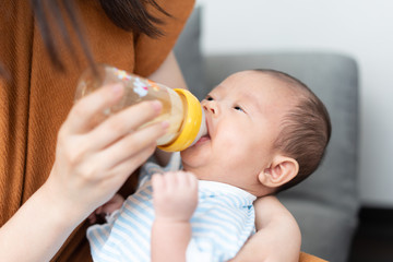 Obraz na płótnie Canvas 哺乳瓶でミルクを飲む赤ちゃん