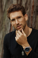 Portrait of handsome man wear glasses and watch on left hand looking at camera