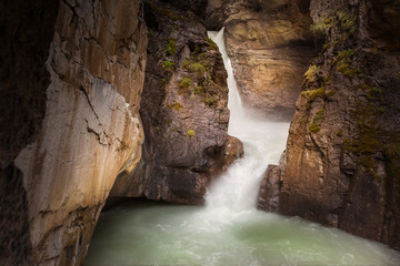 Water churns as it cascades down the rock ravine in Banff National Park, Alberta, Canada