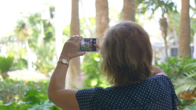 Senior woman taking picture by smartphone in 4K Slow motion 60fps