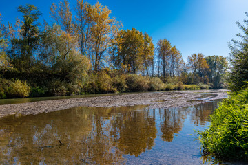 Fototapeta na wymiar Autumn landscape with river Raba trees and blue sky.