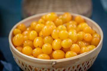 Yellow cherry tomato in bamboo bowl