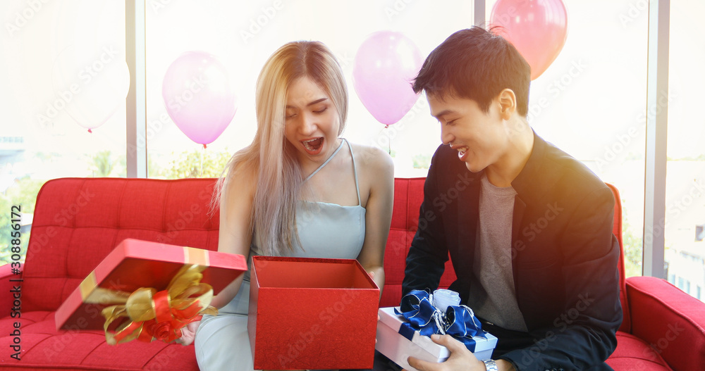 Wall mural Asian couple lover are giving a gift box with Christmas gift in Christmas holiday and happy new year patty