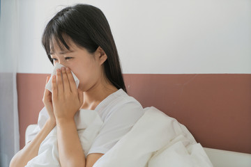 asian young woman get cold in bedroom, sneeze
