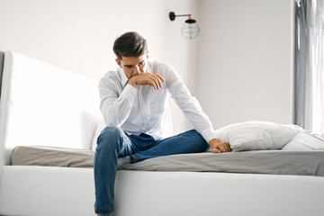 man sitting on sofa and working on laptop