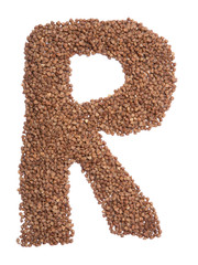 Letter R of the English alphabet from  brown dry buckwheat  on a white isolated background. Food pattern made from groats. Bright alphabet for shops.  Buckwheat for porridge