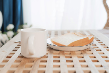 bread and cup of coffee or milk on table, breakfast, food concept