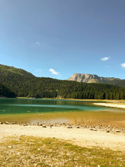 Black lake in Montenegro. Beautiful lake on the background of forest and mountains.
