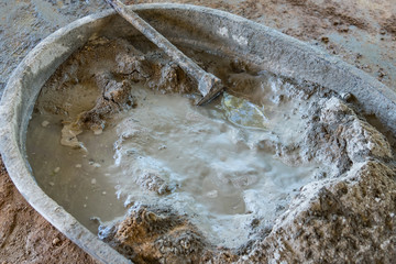 Bucket cement mix with on construction site the ingredients. Brick, Stone, Mortar, Sand.