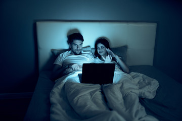 man and woman watching tv in living room