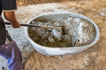 Worker Mixed Cements in Basin Mixer with Hoe in construction site.