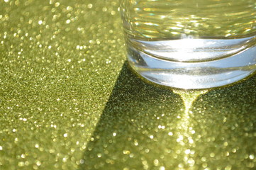 The surface pattern of the glittering sheet is the color that reflects the light of the sun and the water in the glass.