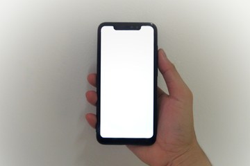 Right hand holding a black smartphone with blank screen.