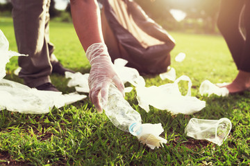 people volunteer keeping garbage plastic bottle into black bag