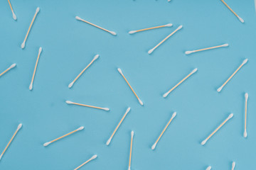 Pattern of cotoon wooden swabs on blue background. Eco friendly concept of zero waste