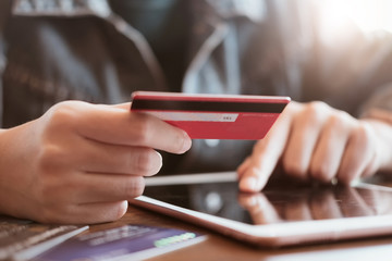 women hold card and use tablet on wood table,Online shopping,hands holding credit card and using laptop.
