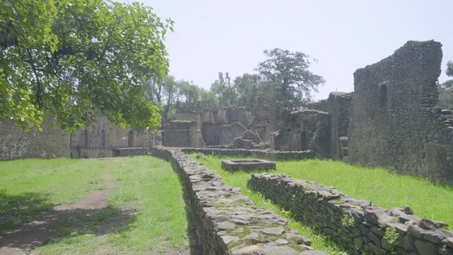 Camera forward view of grounds past the Turkish Baths towards Bakaffa Palace and banqueting hall in the Fasil Ghebbi royal enclosure in Gondar, Ethiopia