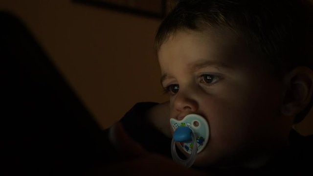Close up of toddler watching tablet. Static