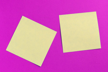 Two square sticker notes on a bright pink background close up