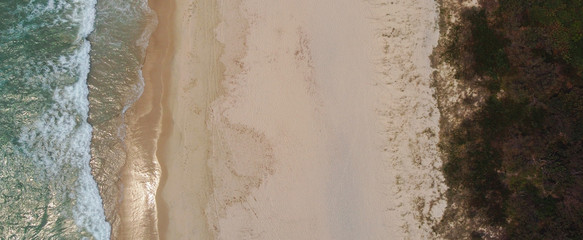 Aerial view of beautiful sandy beach and sea waves, summer holidays travel, reopen tourism, relaxing and wellness concept, drone above view © SewcreamStudio