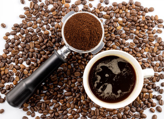 Coffee cob and brown roasted coffee beans and coffee powder on the potta filter isolated on white background.