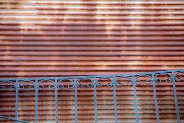 Blue fence in front of rusty shop shutter