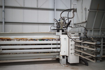 Horizontal hydraulic press for recyclable materials against the wall of a building