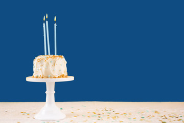Birthday cake with candles on classic blue. Birthday party celebration concept. Horizontal, bold solid background