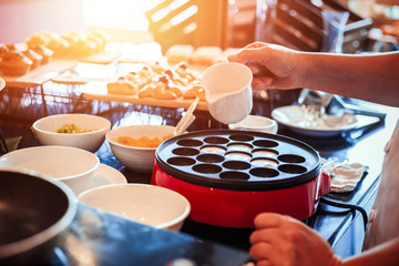 The chef make the dessert on the table and pour coconut milk.