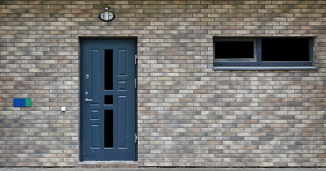 Front  wall of a mass production standard low cost  unfinished residential building with armed door  isolated